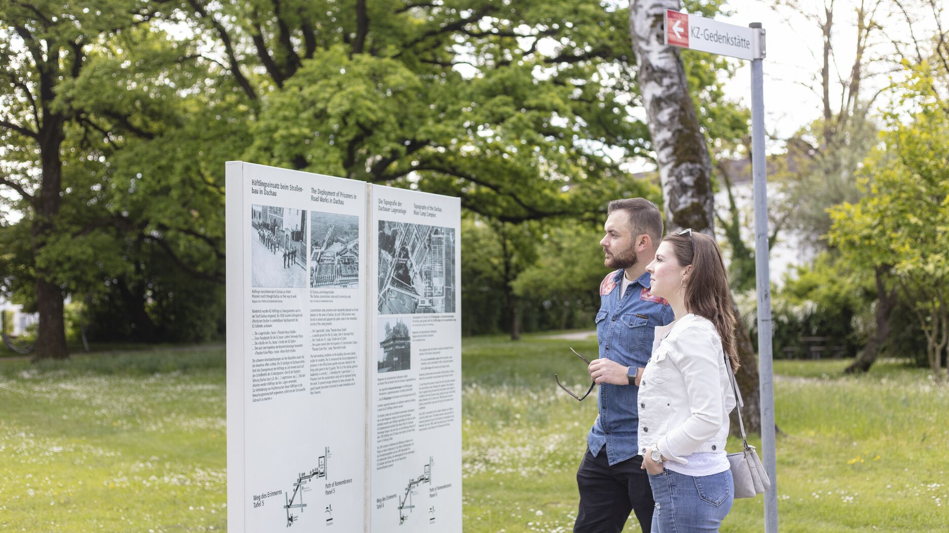 Junges Pärchen auf dem Weg des Erinnerns an einer Tafel