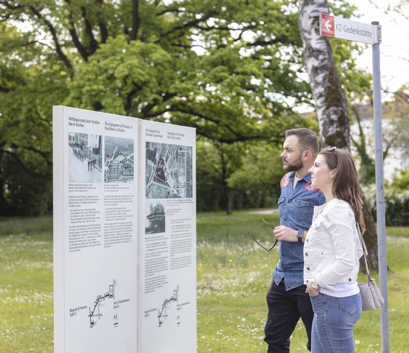 Junges Pärchen auf dem Weg des Erinnerns an einer Tafel