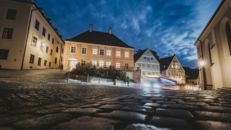 Dachauer Altstadt am Abend, im Vordergrund Kopfsteinpflaster, dahinter die Häuser der Altstadt.