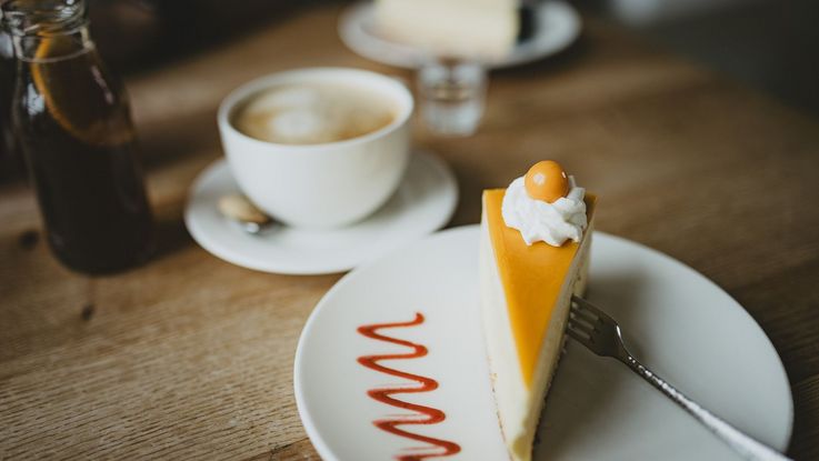 Café und Tortenstück auf einem Tisch angerichtet